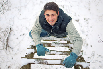 Top view portrait of young smiling handsome man climbing upwards