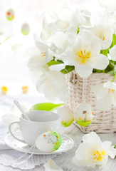 white tulips in a basket and easter eggs