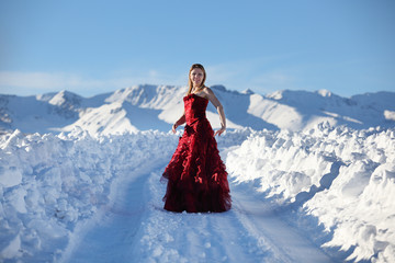 Fototapeta na wymiar The girl in a red dress in mountains