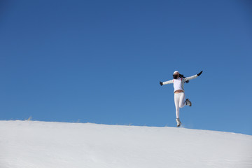 The jumping young girl on snow