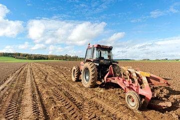 Fototapeta premium Tractors Plowing Field