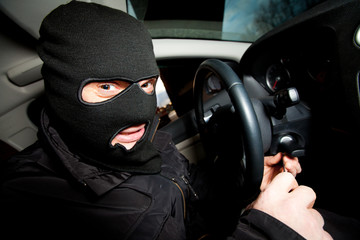 robber and the thief in a mask hijacks the car