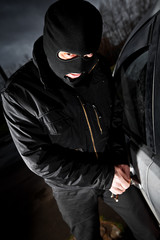 robber and the thief in a mask hijacks the car