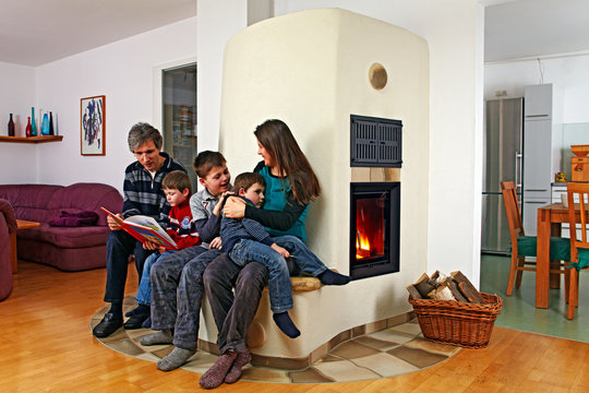 family sitting on the bench of a masonry stove 01