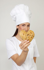 Frau mit Brötchen in Herzform Bäckerin