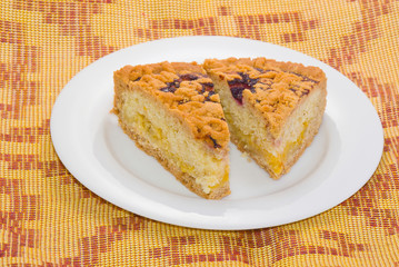 Two pieces of lemon pie with cherry top on a white plate..