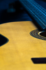 Detail shot of a beautiful  acoustic guitar on dark velvet