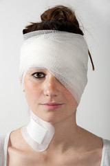 verletzte Frau mit Verband um den Kopf