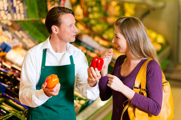 Frau im Supermarkt und Verkäufer