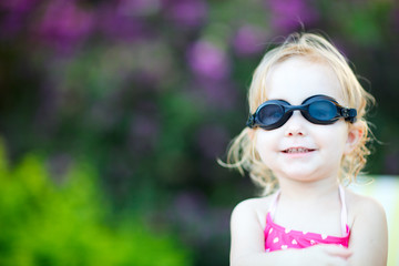 Adorable toddler girl in swimming glasses