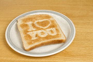 Slice of toast on plate saying I love you