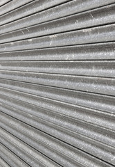 Closed metal shop security shutter close up.