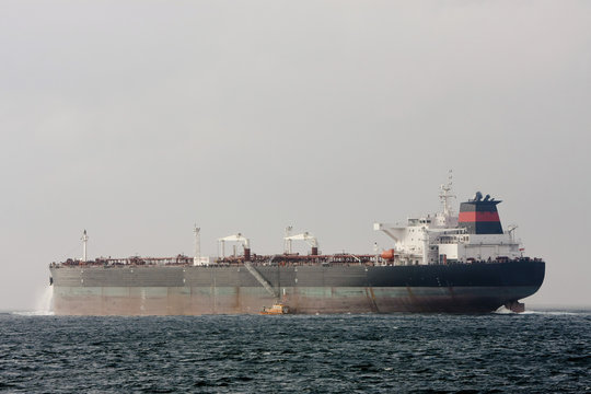 Oil supertanker at sea with Pilot Boat