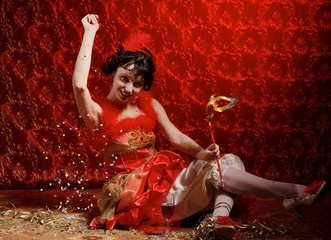 Lady in red dress witn mask throws confetti