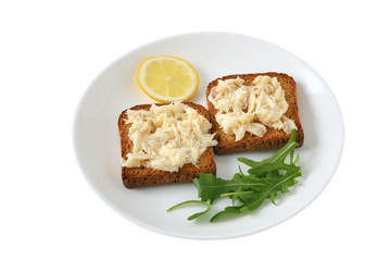 toasts with codfish and lemon on a plate