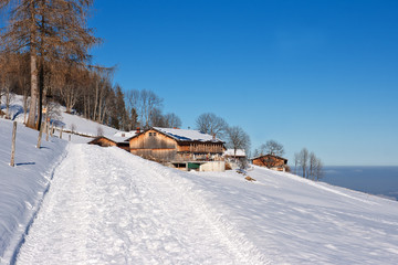 Winterwanderweg in den bayrischen Alpen mit blauem Himmel