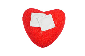 red plastic heart with two condoms