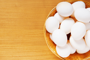 Many white eggs on the wooden table
