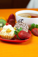 lemon,lemon tea,mandarin,kiwi,cake and strawberries lying on the