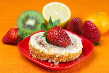 cake,kiwi,lemon,mandarin and strawberries lying on the orange fa
