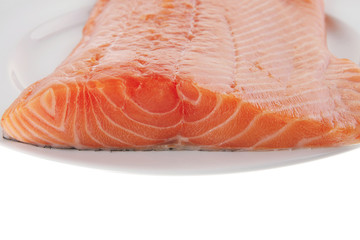 fresh uncooked salmon fillet on white plate