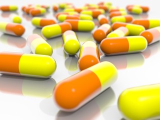 Orange and Yellow pills on a mirroring ground.