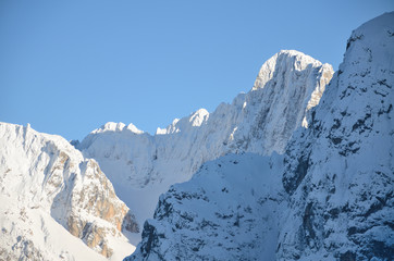 Snowcovered mountain peak with cross on top