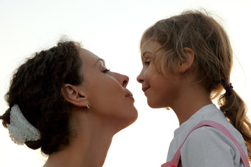 portrait of mother and daughter looking to each other, side view