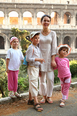 young mother, little son and two daughters are near Colosseum