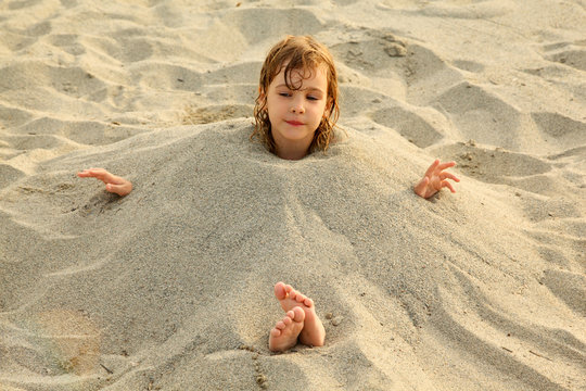 Girl After Swimming Is Buried In Sand On Beach