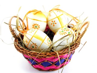 Hand painted easter eggs in a basket on a white background