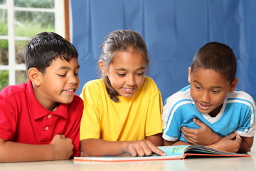 Learning together three happy young school kids