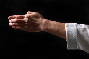 Fist. Hand fighter karate on the black background