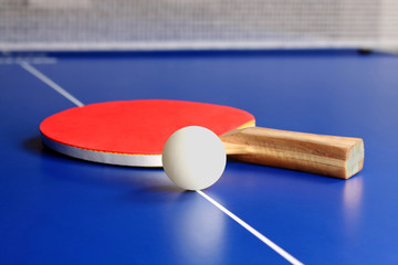 raqueta roja y una pelota de tenis de mesa