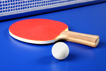 raqueta roja y una pelota de tenis de mesa