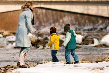 Familie auf Winterspaziergang am Fluss