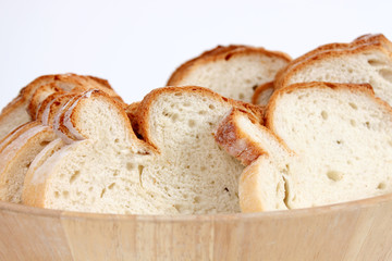 pan fresco cortado en trozos dentro de plato hondo de madera