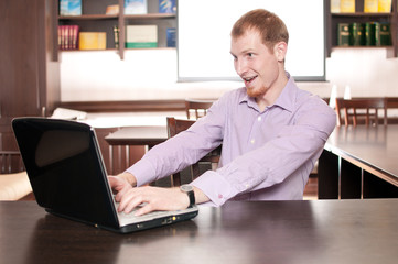 Fototapeta na wymiar Emotional businessman with laptop