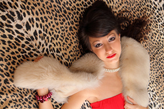 ragazza con pelliccia su letto leopardato