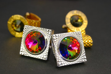 Two pairs bright cuff links on a dark background