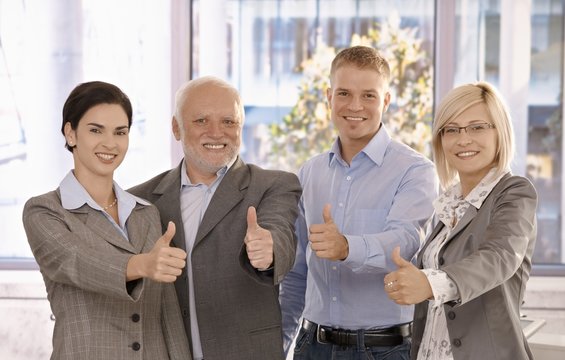 Successful businessteam giving thumbs up