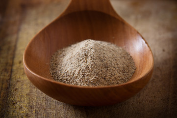 White pepper on wooden spoon