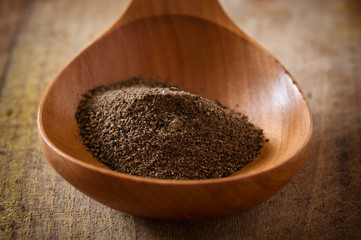 Black pepper on wooden spoon