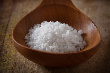Pile of sea salt with wooden spoon