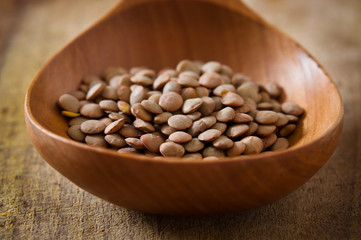 Green lentils in wooden spoon