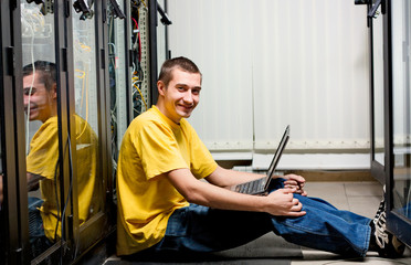 The engineer sits in datacenter and configuring equipment. - 29247226
