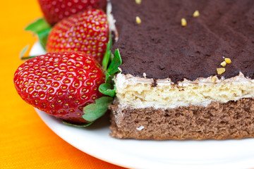 cake on a plate and strawberries lying on the orange fabric
