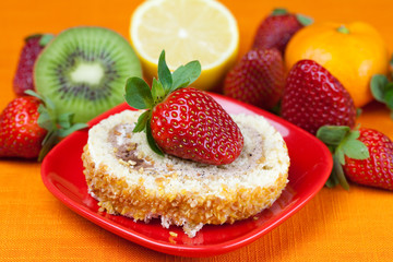 cake,kiwi,lemon,mandarin and strawberries lying on the orange fa