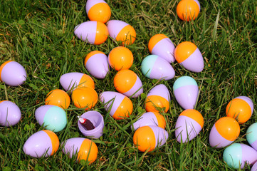 Fototapeta na wymiar Cluster of plastic Easter eggs with opened one showing candy