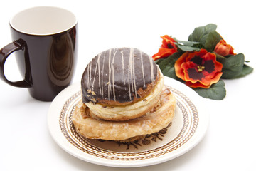 Krapfen mit Blumen und Tasse